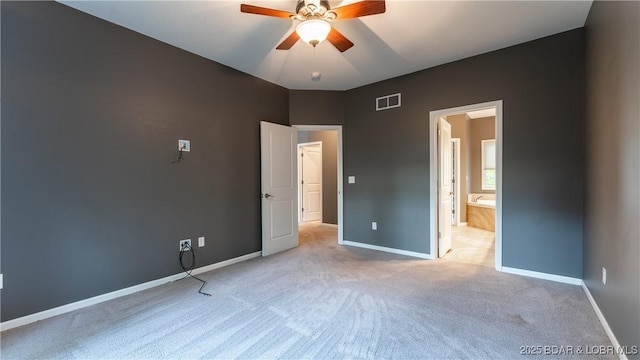 unfurnished bedroom featuring visible vents, ensuite bath, light carpet, and baseboards