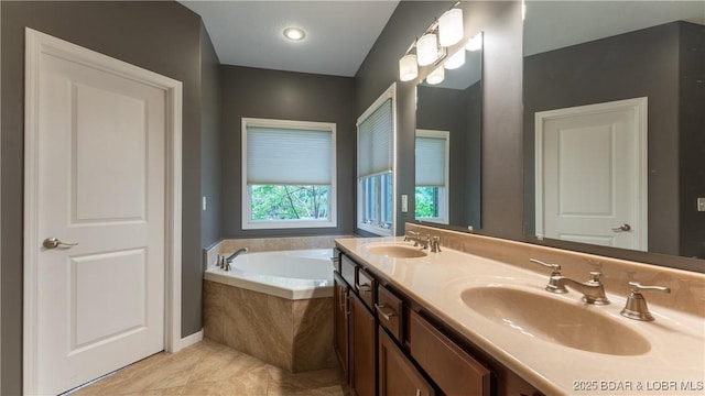 bathroom featuring double vanity, a garden tub, and a sink