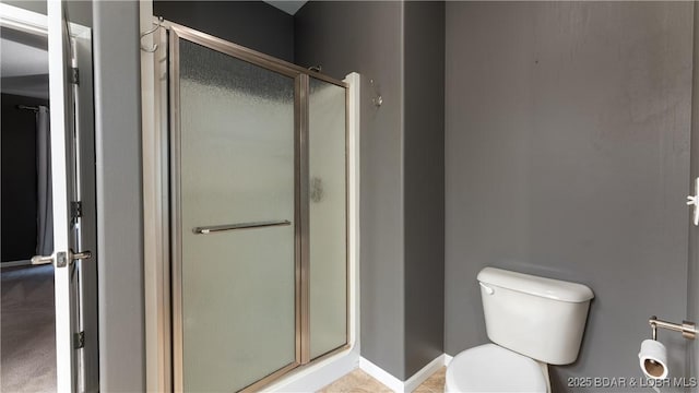 full bath featuring a stall shower, baseboards, and toilet