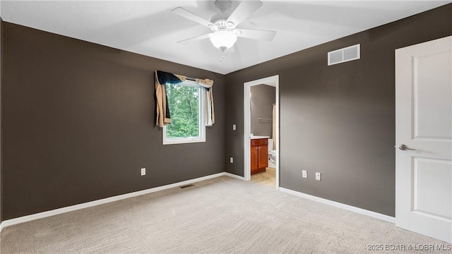 spare room with ceiling fan, light colored carpet, visible vents, and baseboards