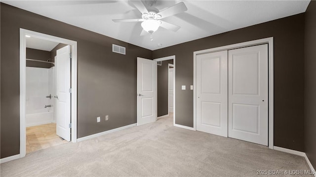 unfurnished bedroom featuring a closet, visible vents, light carpet, and baseboards