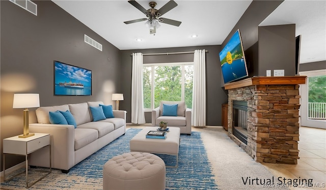 tiled living room with a ceiling fan, visible vents, a fireplace, and carpet flooring