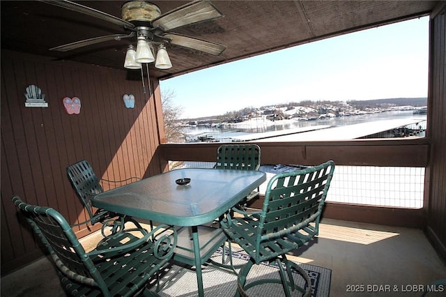 snow covered back of property featuring outdoor dining area and a ceiling fan