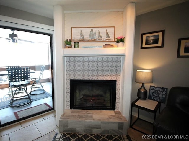 interior details with a ceiling fan and a tiled fireplace