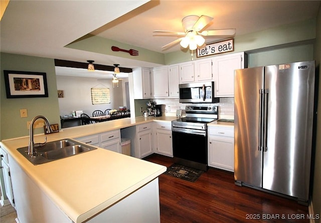 kitchen featuring a sink, stainless steel appliances, a peninsula, and light countertops