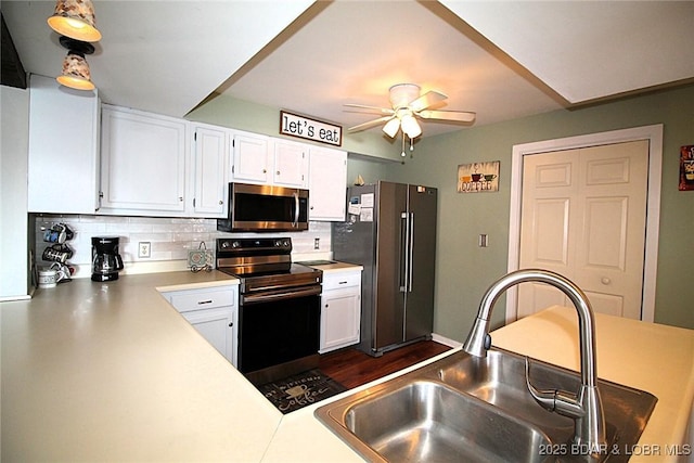 kitchen with stainless steel appliances, a sink, white cabinetry, light countertops, and backsplash