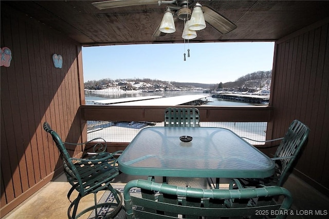 snow covered back of property with a ceiling fan