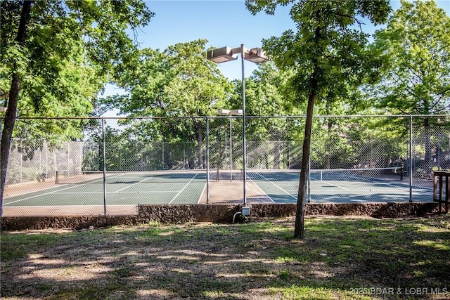 view of tennis court featuring fence