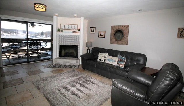 living area with visible vents, a fireplace, and light tile patterned floors