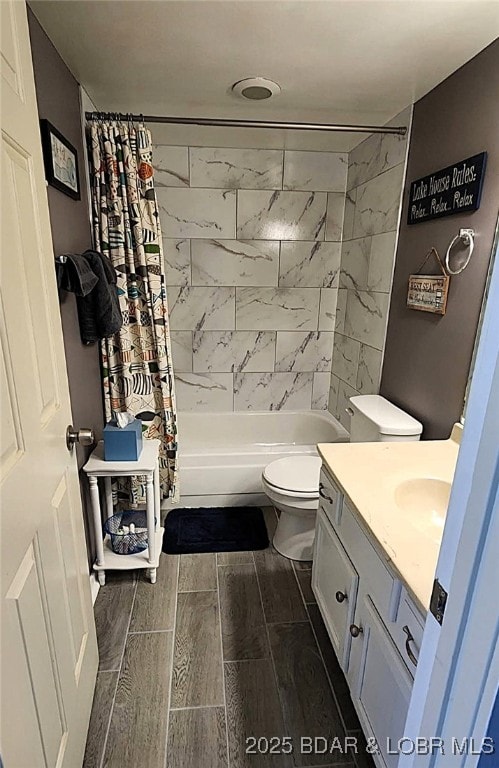 full bathroom featuring toilet, shower / tub combo, vanity, and wood finish floors