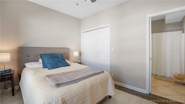 bedroom featuring multiple closets, wood finished floors, a ceiling fan, and baseboards