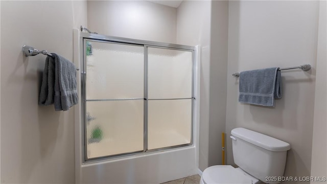 full bathroom featuring toilet and shower / bath combination with glass door