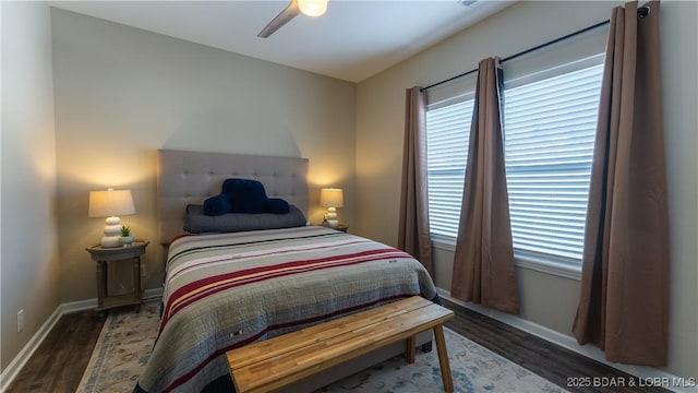 bedroom with multiple windows, ceiling fan, baseboards, and wood finished floors