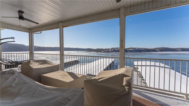 deck with a water view and a ceiling fan