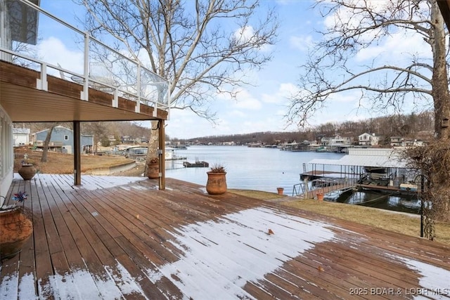 wooden deck with a dock and a water view