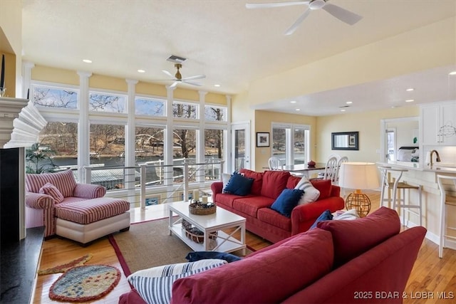 living area with a ceiling fan, light wood-type flooring, visible vents, and recessed lighting