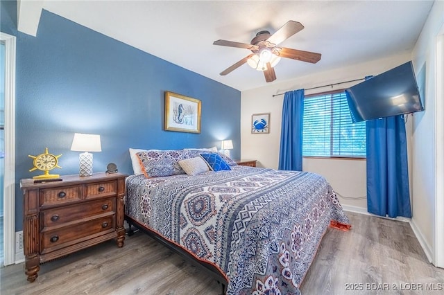 bedroom featuring ceiling fan, baseboards, and wood finished floors