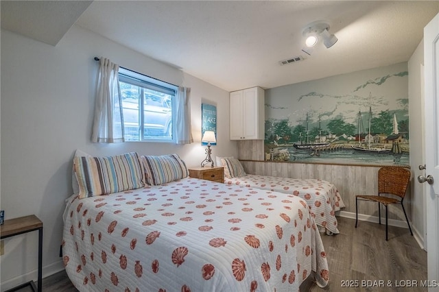 bedroom with visible vents and wood finished floors