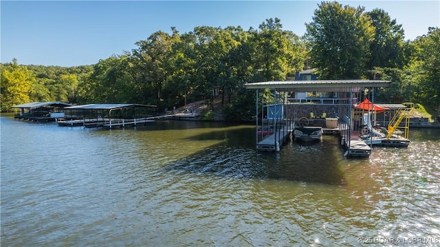 view of dock with a forest view, a water view, and boat lift