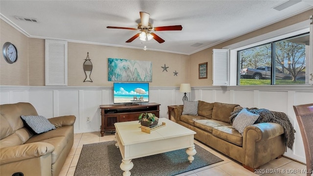 living area with light tile patterned floors, visible vents, a textured ceiling, and ornamental molding