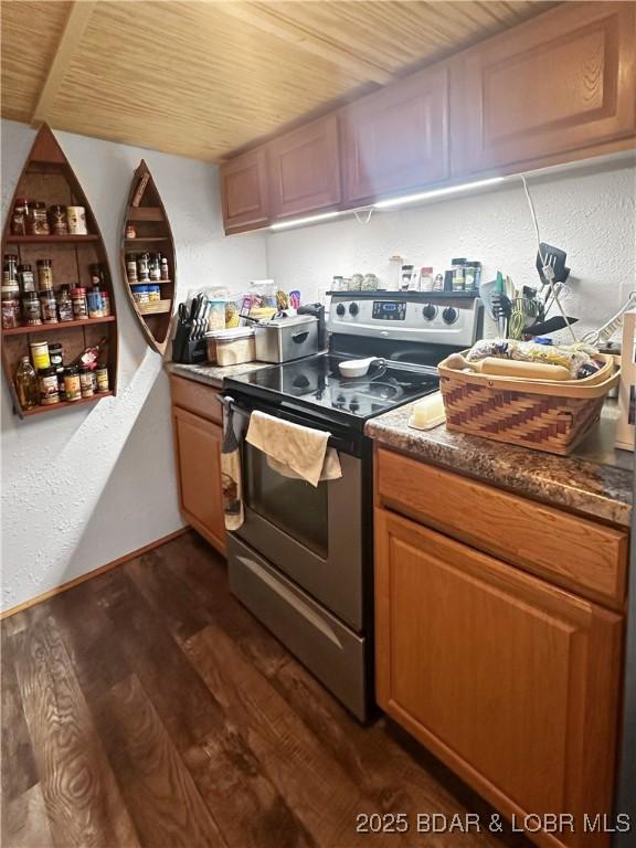 kitchen with wooden ceiling, stainless steel range with electric cooktop, brown cabinetry, dark countertops, and dark wood finished floors