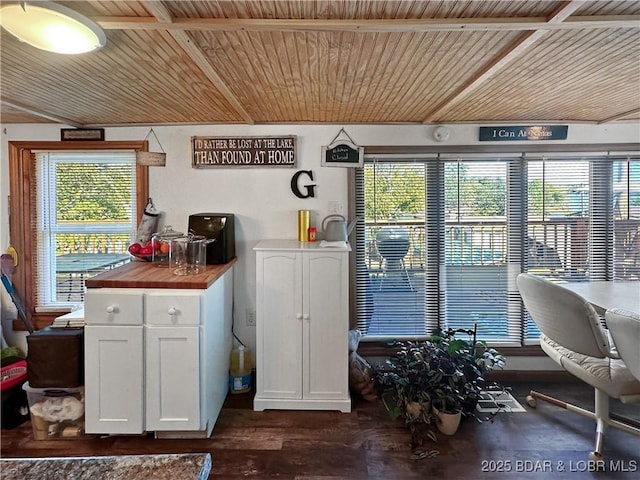 interior space with wooden ceiling, butcher block counters, dark wood-style floors, and white cabinets