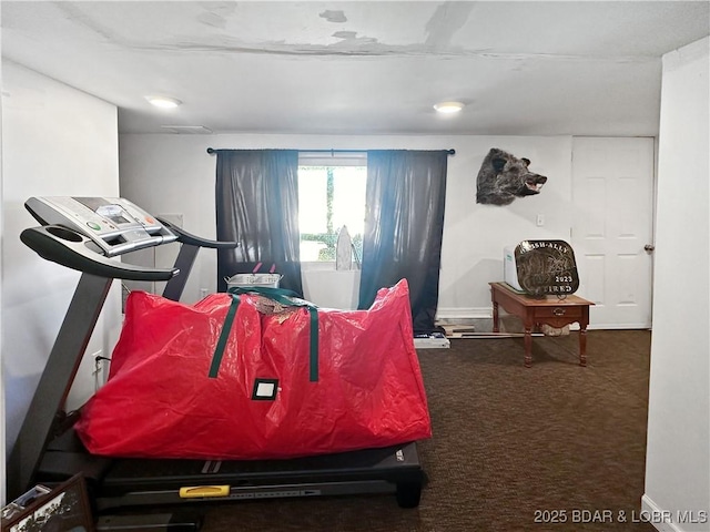 interior space with baseboards and dark colored carpet