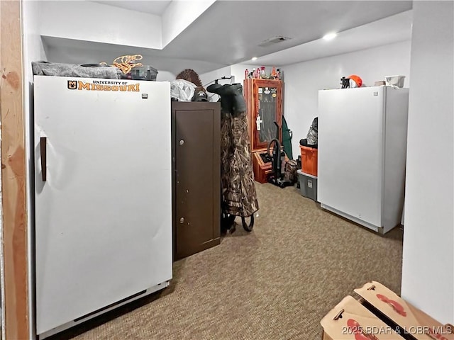 kitchen with visible vents, carpet, and freestanding refrigerator