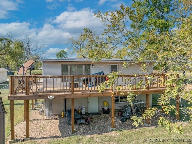 rear view of house featuring metal roof and a wooden deck