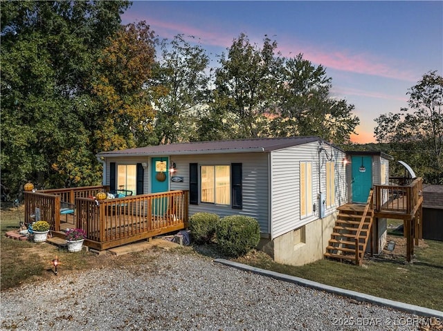 manufactured / mobile home featuring a deck, metal roof, and driveway