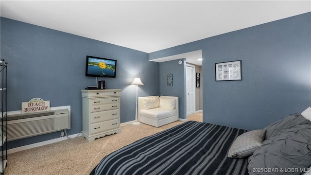 bedroom featuring light carpet, an AC wall unit, and baseboards