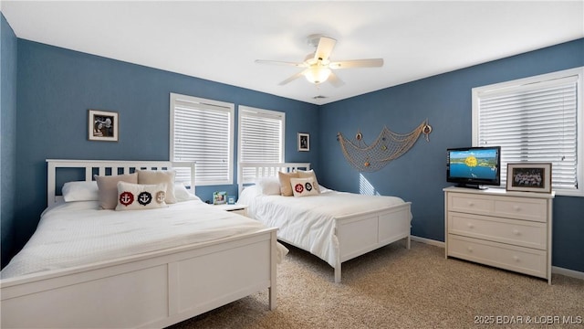 bedroom featuring a ceiling fan, light carpet, and baseboards