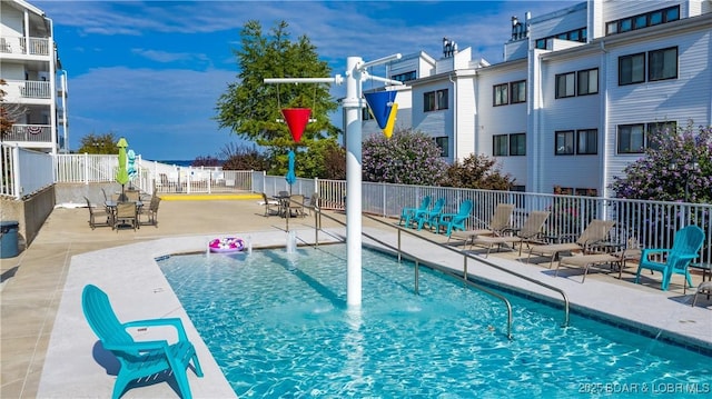 community pool with a residential view, fence, and a patio