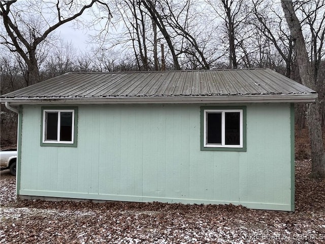 view of side of property with an outbuilding and metal roof