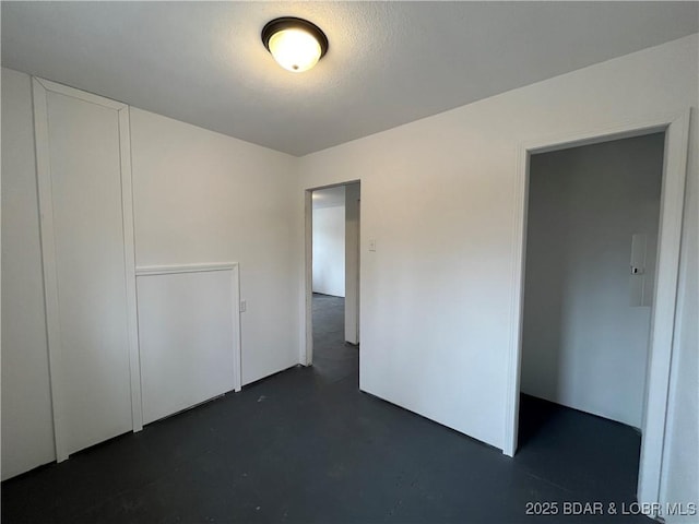 unfurnished bedroom with concrete flooring