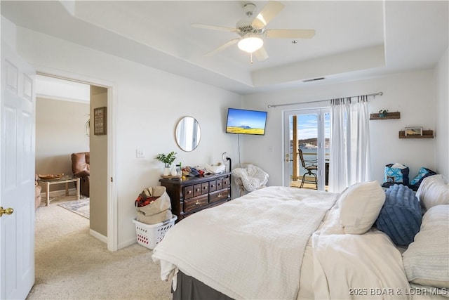 bedroom with baseboards, access to outside, a raised ceiling, and light colored carpet