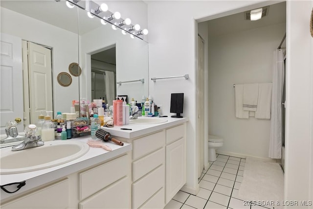 full bath featuring tile patterned flooring, a sink, toilet, and double vanity