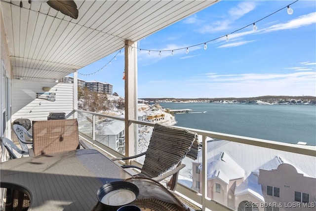 balcony featuring a water view and ceiling fan