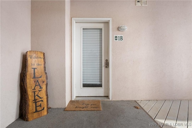 entrance to property featuring stucco siding