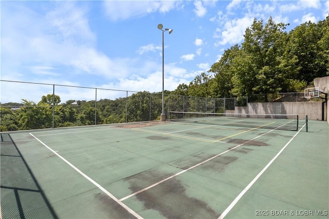 view of tennis court featuring fence