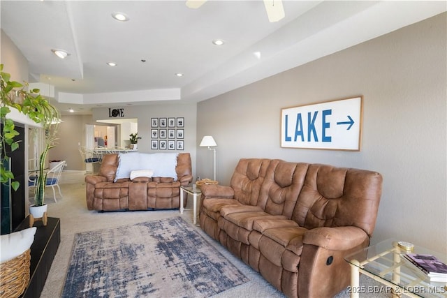 living area with carpet floors, a tray ceiling, and recessed lighting