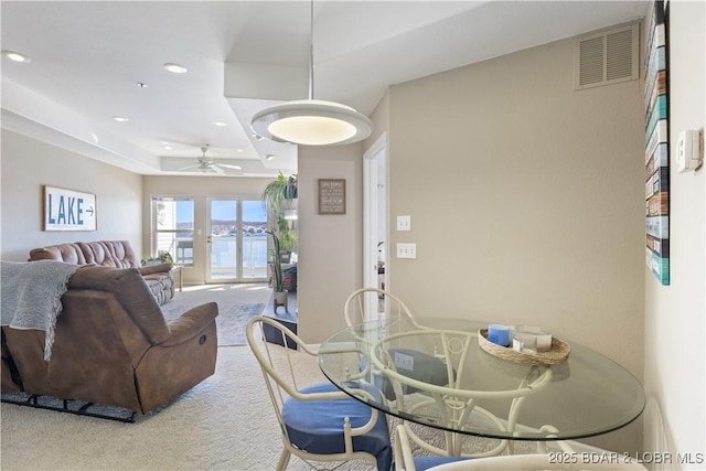 carpeted dining area featuring a ceiling fan, visible vents, a tray ceiling, and recessed lighting