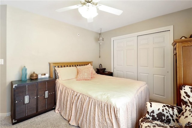 bedroom featuring a ceiling fan, a closet, light carpet, and baseboards