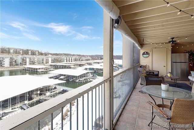 balcony featuring a water view and a ceiling fan