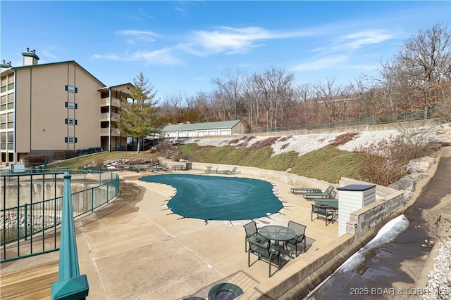 pool with a patio and fence