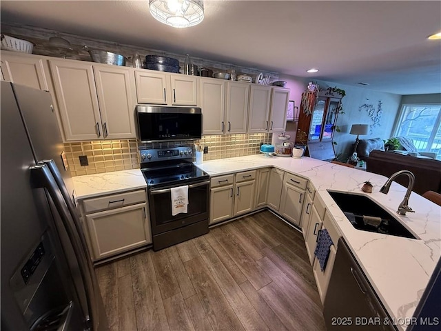 kitchen featuring dark wood-style flooring, a sink, electric range oven, refrigerator with ice dispenser, and backsplash