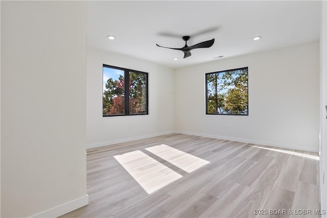 unfurnished room with baseboards, ceiling fan, light wood-style floors, and a healthy amount of sunlight