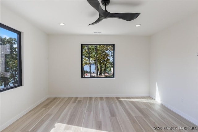 empty room with a healthy amount of sunlight, light wood-style flooring, and visible vents