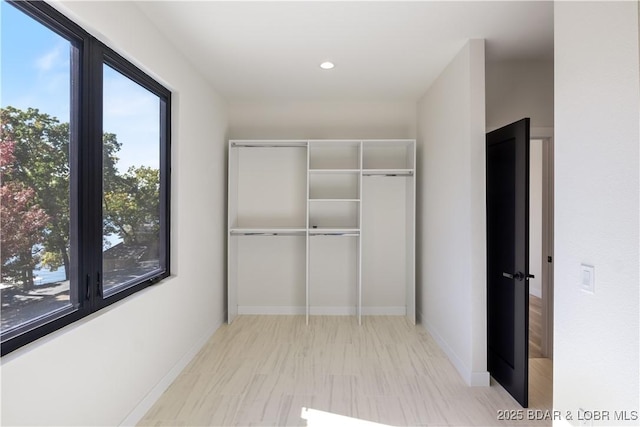 hall with recessed lighting and baseboards