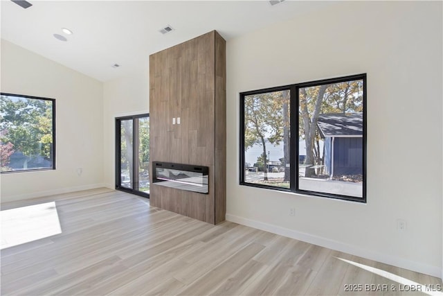 unfurnished room with lofted ceiling, recessed lighting, visible vents, light wood-style flooring, and baseboards